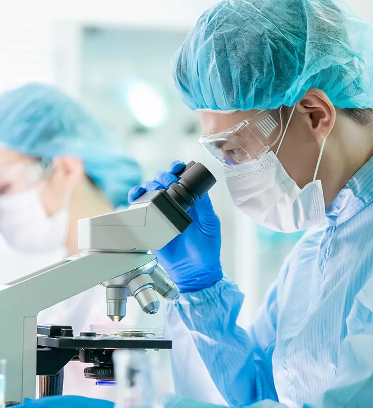 Sincronización horaria precisa para garantizar la fiabilidad de los análisis de laboratorio Técnico de laboratorio analizando una muestra con un microscopio